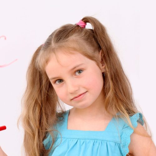 Cute little girl with felt pen and ABC latters on board