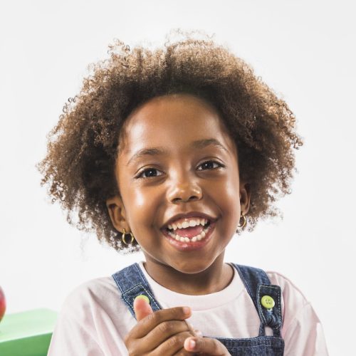 kid-sitting-with-books-smiling-studio (1)